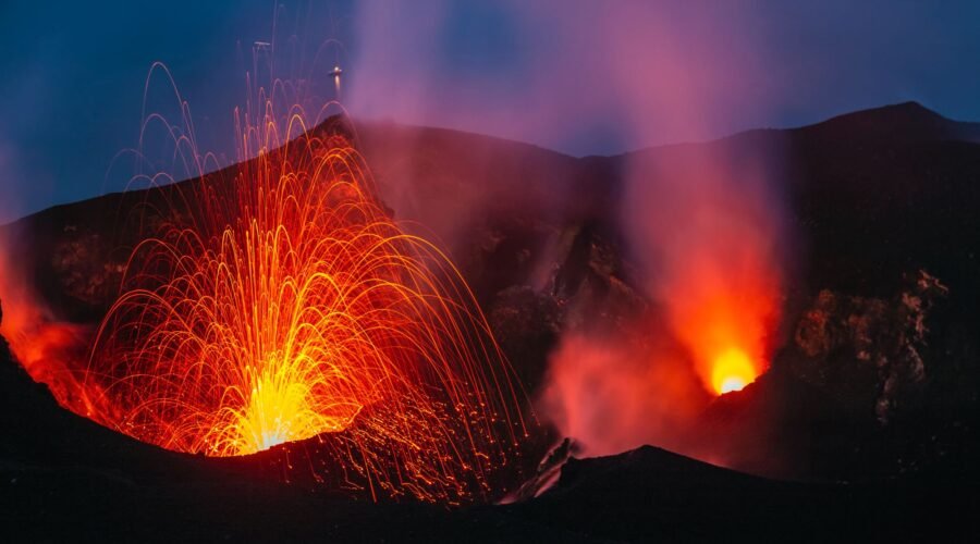 The eruption of active volcano Stromboli spraying lava into the night, shot in blue hour in Italy.